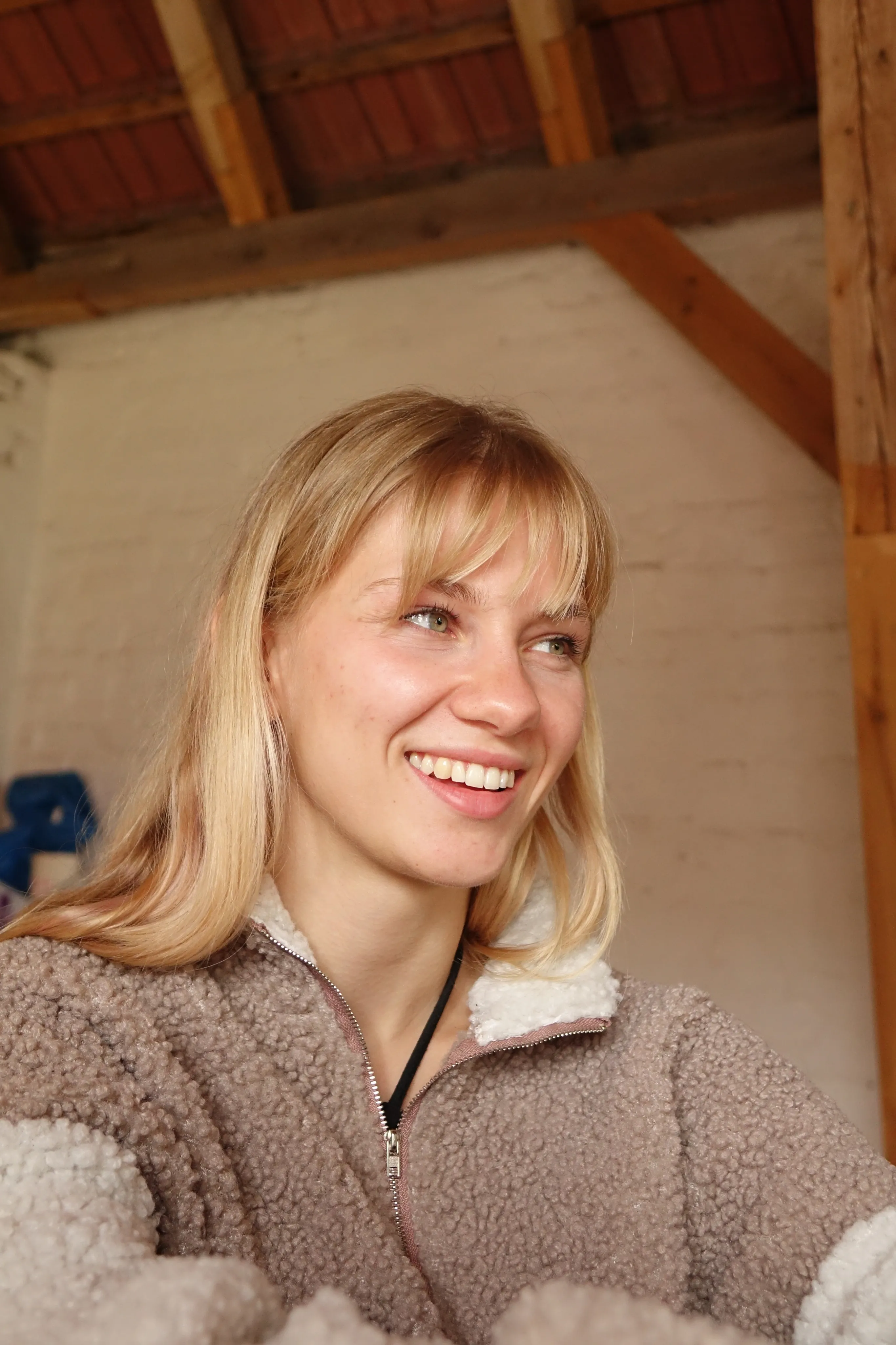 Portrait von Rebecca, eine blonde junge Frau, die nach rechts schaut.